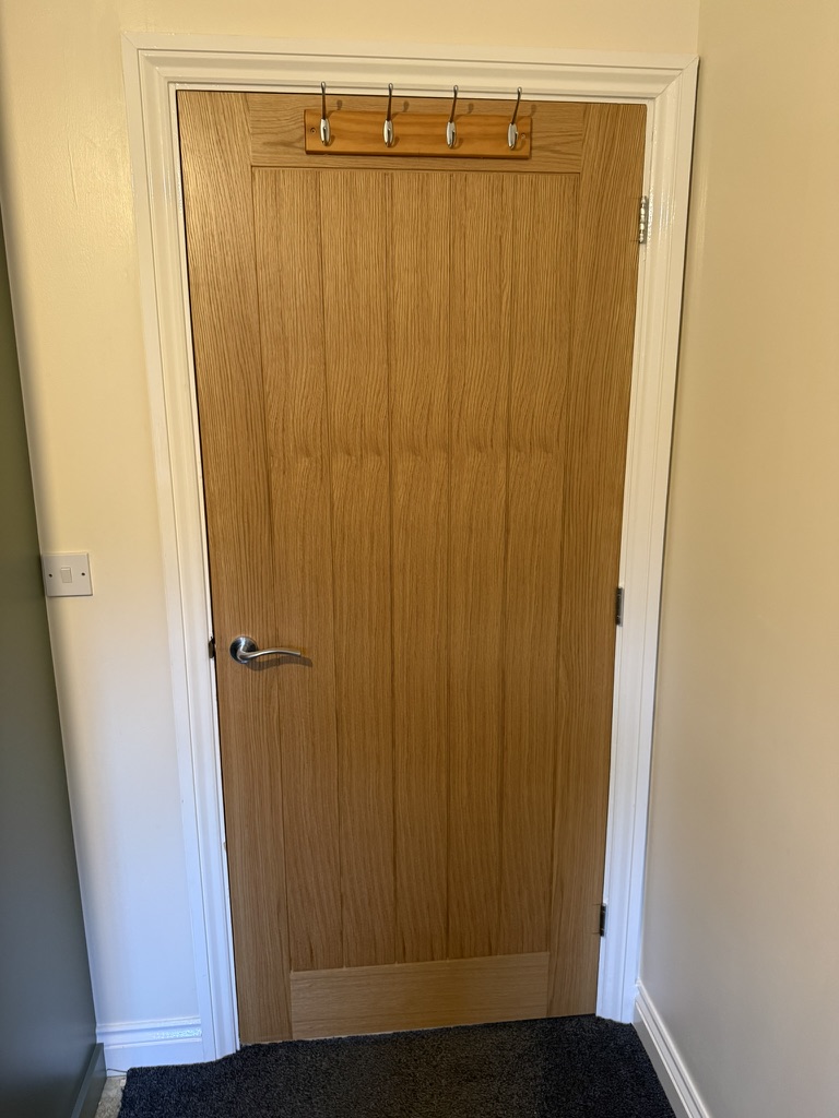 Internal oak door with brushed handle and clean architrave